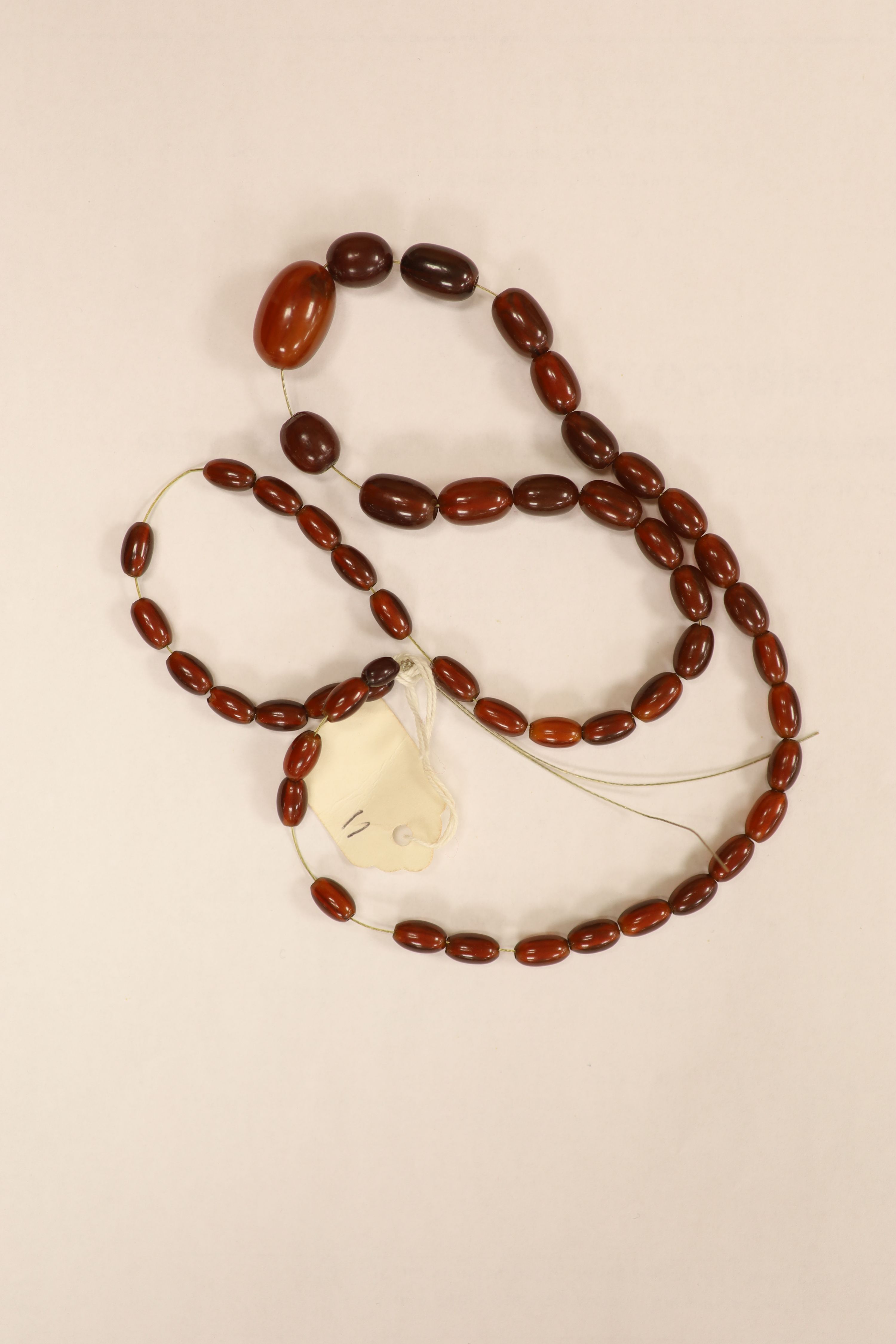 Nine assorted single strand amber bead necklaces, longest approximately 46cm, gross weight 173 grams and one simulated amber bead necklace.